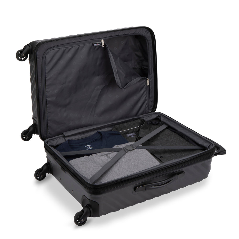 Side view of a black hardside luggage called MOD designed by Swiss Gear sold at Bentley, showcasing its interior that features compression straps and a divider panel.